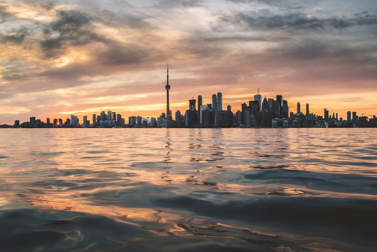 Toronto skyline and CN Tower across Lake Ontario at golden hour